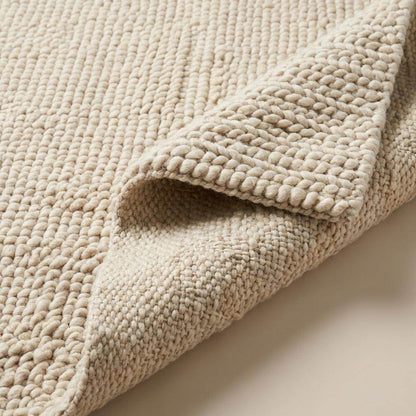 Handmade chunky wool rug with thick, soft texture in neutral tones for cozy, minimalist living room decor