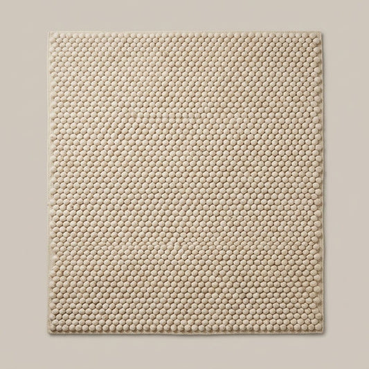Chunky Wool Rug in cream oatmeal wool, with a thick handwoven surface of tightly spaced rounded pebble tufts and finished edges.