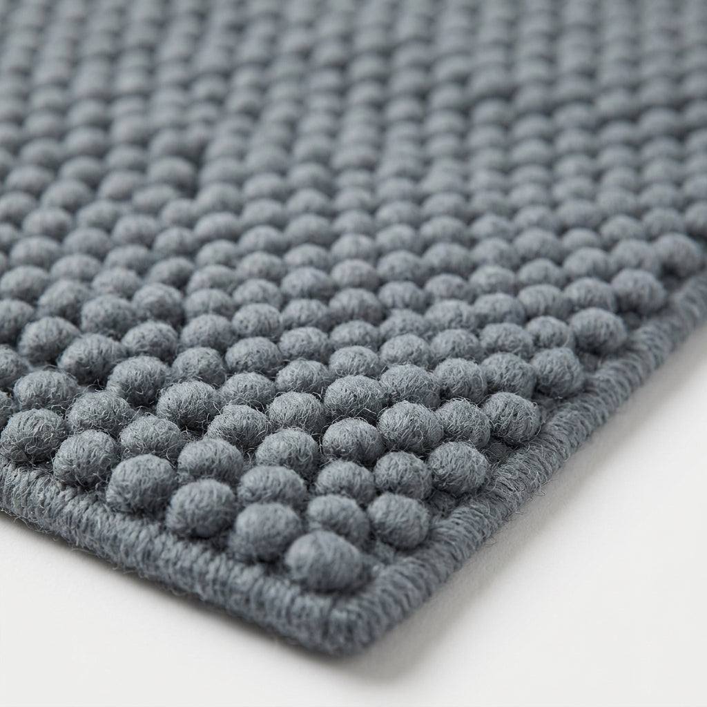 Chunky Wool Rug in slate blue-gray wool-like fibers, with a thick handwoven surface of raised rounded pebbles and finished edges.