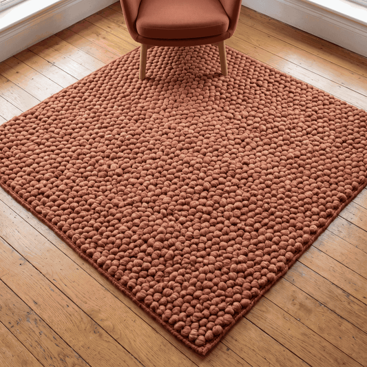 Chunky Wool Rug in rust terracotta with a thick, handwoven pebble texture and rounded rectangular shape