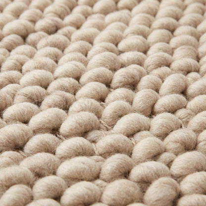 Handmade chunky wool rug with thick knit texture in neutral beige for cozy living room and bedroom decor