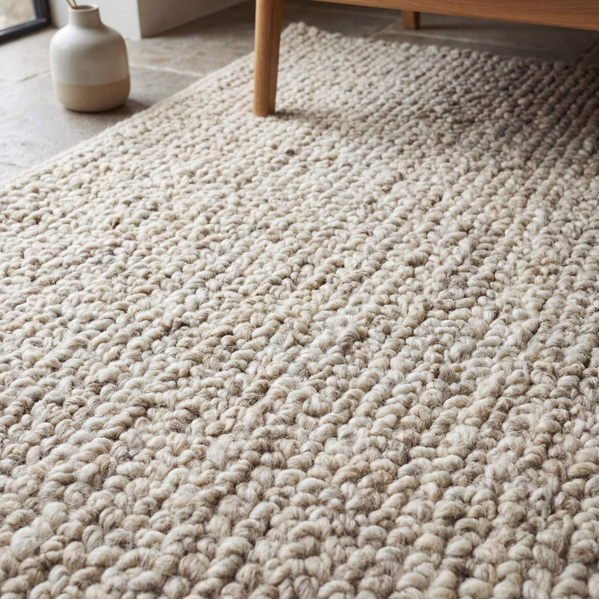 Handmade chunky wool rug with thick, textured natural fibers in a neutral tone for cozy minimalist living room decor