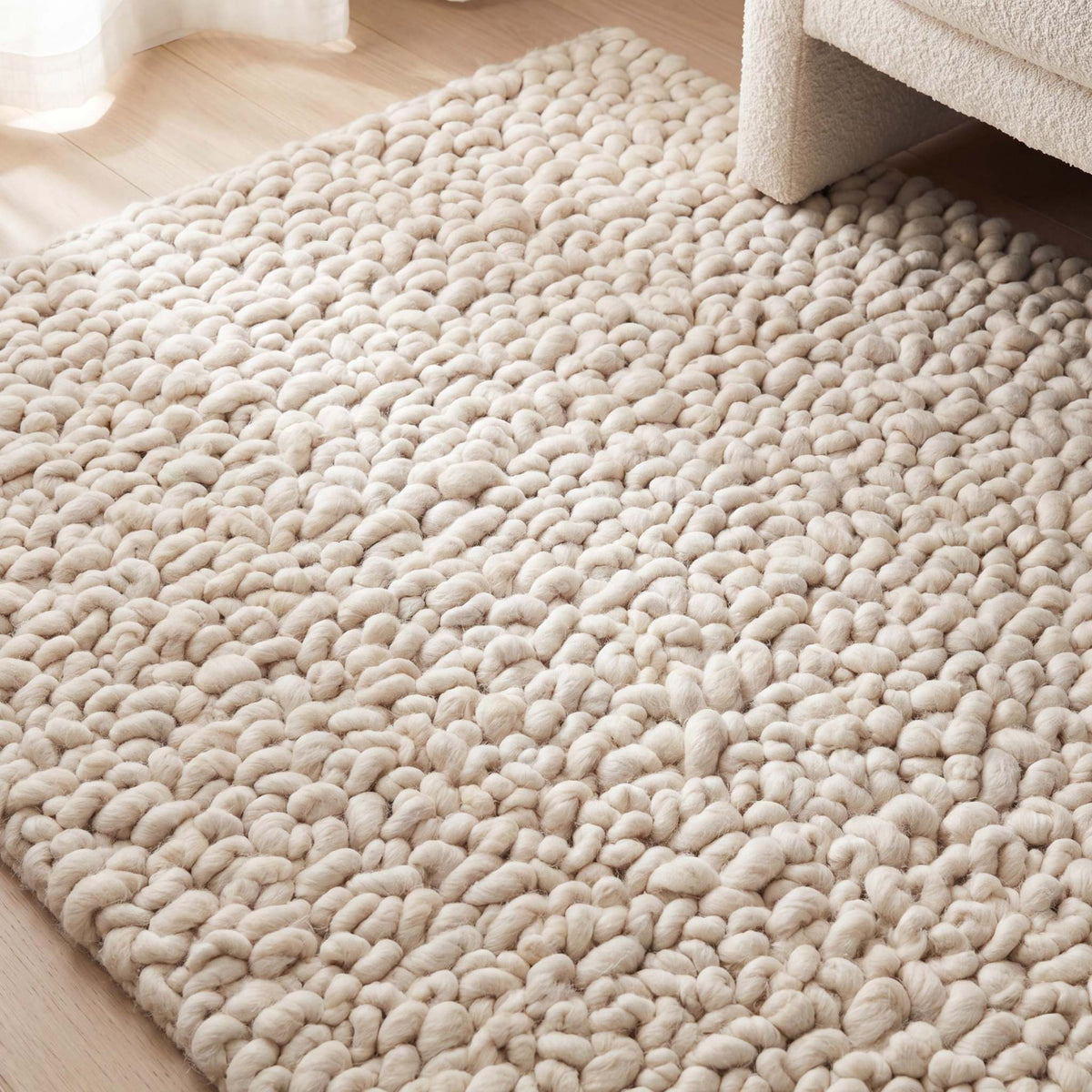 Handmade chunky wool rug with thick, textured loops in a neutral color for cozy, minimalist home decor
