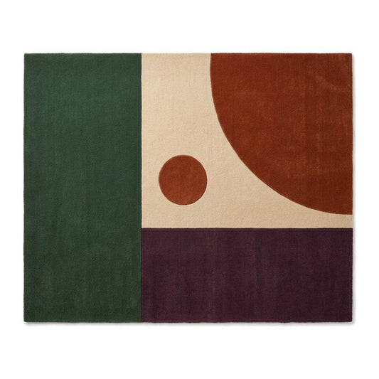 Color Block Rug in deep green, cream, burnt orange and plum wool, with bold geometric panels, a curved shape and dot