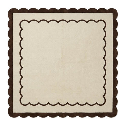 Cream and brown wool rug with a plush surface, featuring the Cream & Chocolate Scalloped Border and wavy edges.
