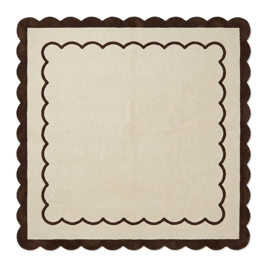 Cream and brown wool rug with a plush surface, featuring the Cream & Chocolate Scalloped Border and wavy edges.