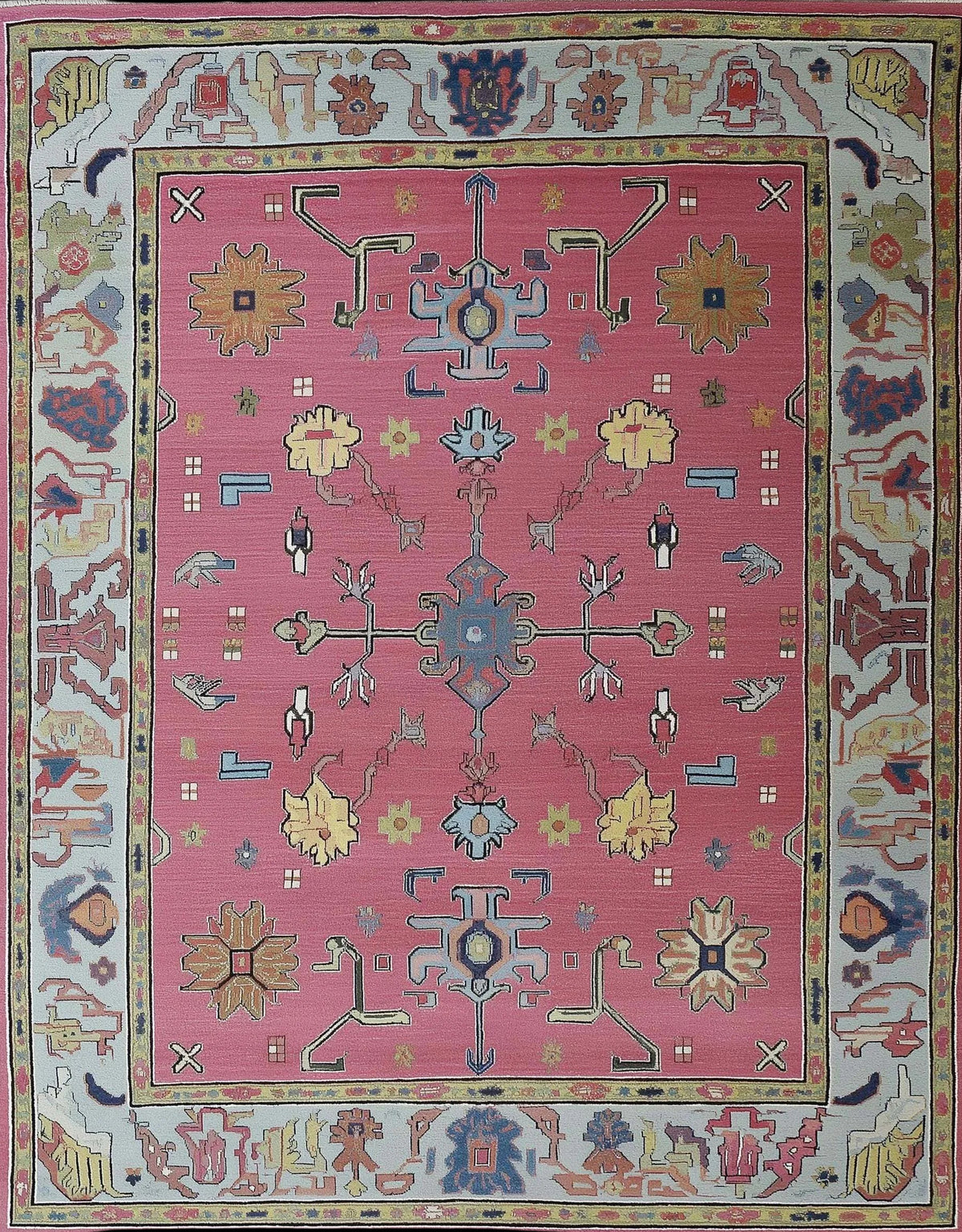 Dusty Rose Oushak Rug with hand-tufted wool floral and geometric patterns in dusty blue, pink, and cream colors