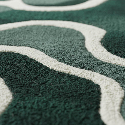 Emerald green wool rug with abstract cream wavy lines in Scandinavian style