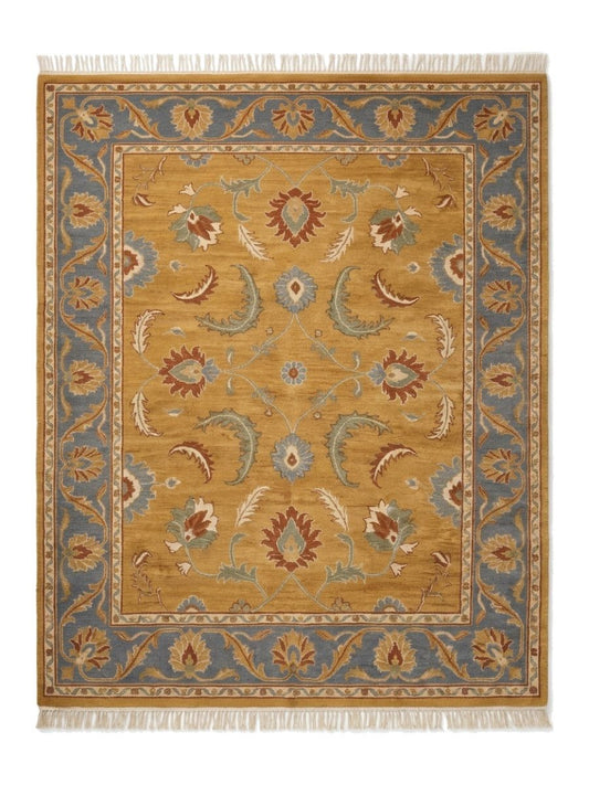 Gold Oushak Rug in mustard wool with rust, blue, sage and ivory floral motifs, slate blue border and fringe