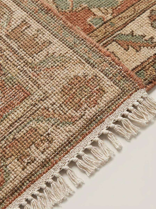 Hand knotted Oushak runner rug with vintage floral and animal motifs in dusty rose and sage green wool