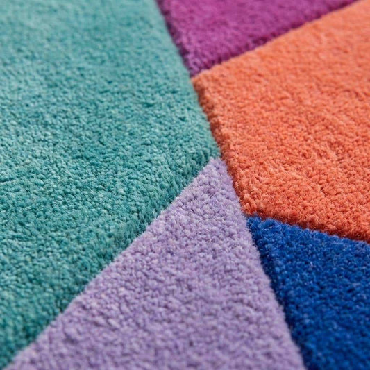 Hand tufted abstract geometric rug with modern color block design and irregular shape