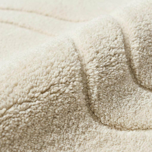 Close-up of dense hand tufted wool pile showing soft plush fibers and carved contour detailing in cream ivory tone. __etsy:7708290438