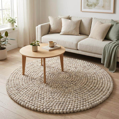 Handmade round wool felt ball rug with pebble texture in neutral Scandinavian nursery decor colors