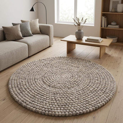 Handmade round wool felt ball rug with neutral pebble design for Scandinavian nursery decor