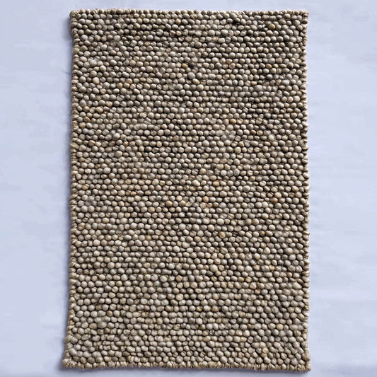 Handmade textured wool mat in natural beige pebble design for cozy modern home decor