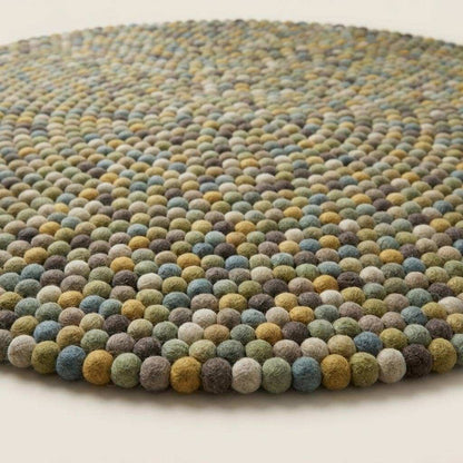 Handmade wool felt ball rug in sage green with earthy tones for nursery and playroom decor