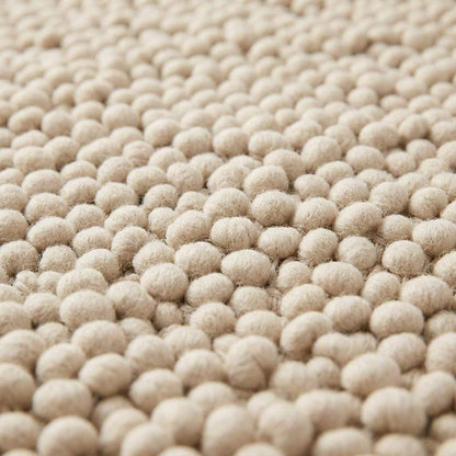 Handwoven chunky wool pebble rug in natural ivory with thick texture for modern nursery and living room interiors