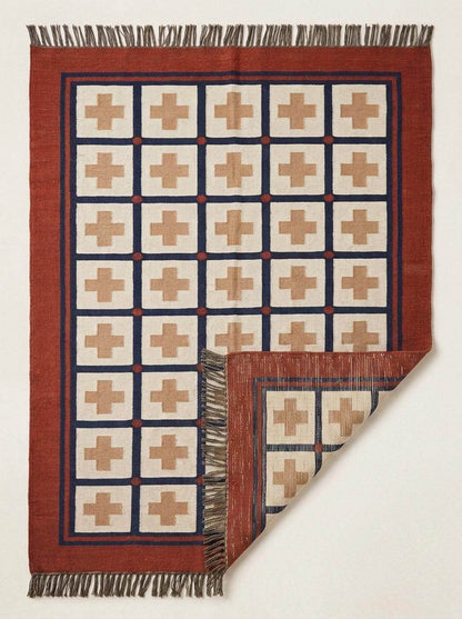 Handwoven flatweave wool rug with Southwestern cross pattern in rust and navy geometric design