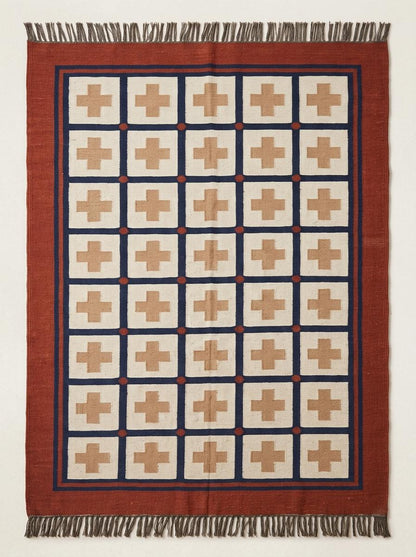 Handwoven flatweave wool rug with Southwestern cross geometric design in rust and navy colors for living room