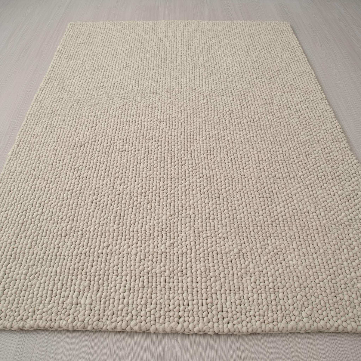 Handwoven Neutral Wool area rug in a soft beige tone, featuring a loop-textured natural wool fibre surface with subtle depth and tactile appeal.