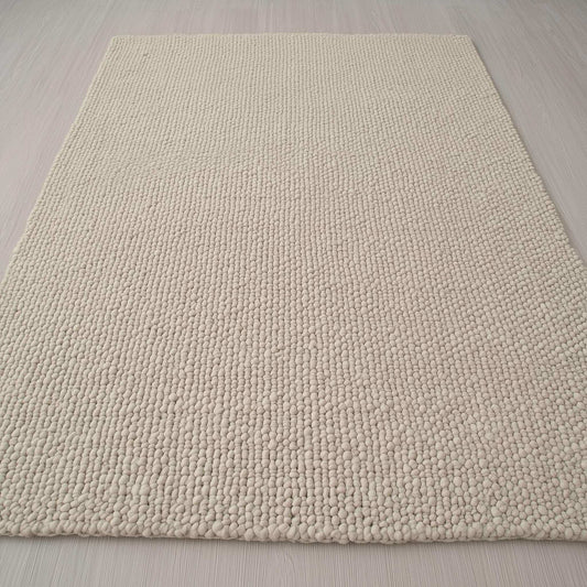 Handwoven Neutral Wool area rug in a soft beige tone, featuring a loop-textured natural wool fibre surface with subtle depth and tactile appeal.