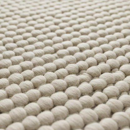 Handwoven Neutral Wool area rug in a soft beige tone, featuring a distinctive loop texture and natural wool fibers.