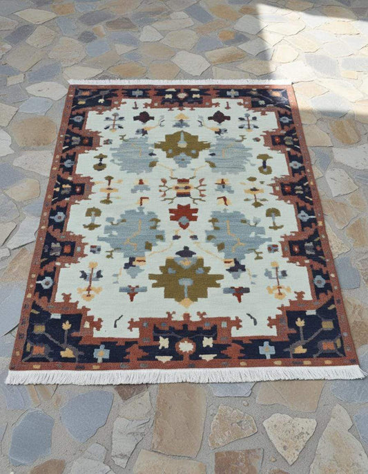 Handwoven Southwestern Kilim rug with cream, rust, navy geometric patterns and knotted fringes