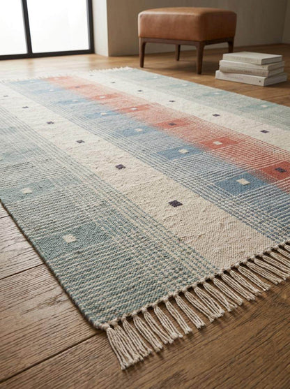 Handwoven tartan flatweave rug in sage green and terracotta with Scandinavian modern plaid design