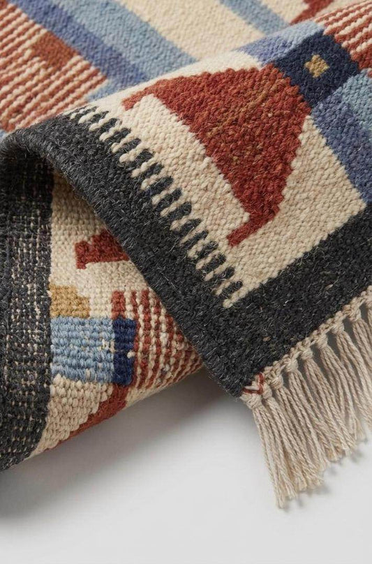 Handwoven wool flatweave rug with geometric kilim design in Scandinavian Southwestern style, featuring terracotta, blue, and cream colors.