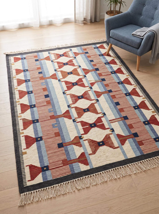 Handwoven wool flatweave rug with geometric kilim design in ivory, terracotta, blue, and grey colors, Scandinavian Southwestern style