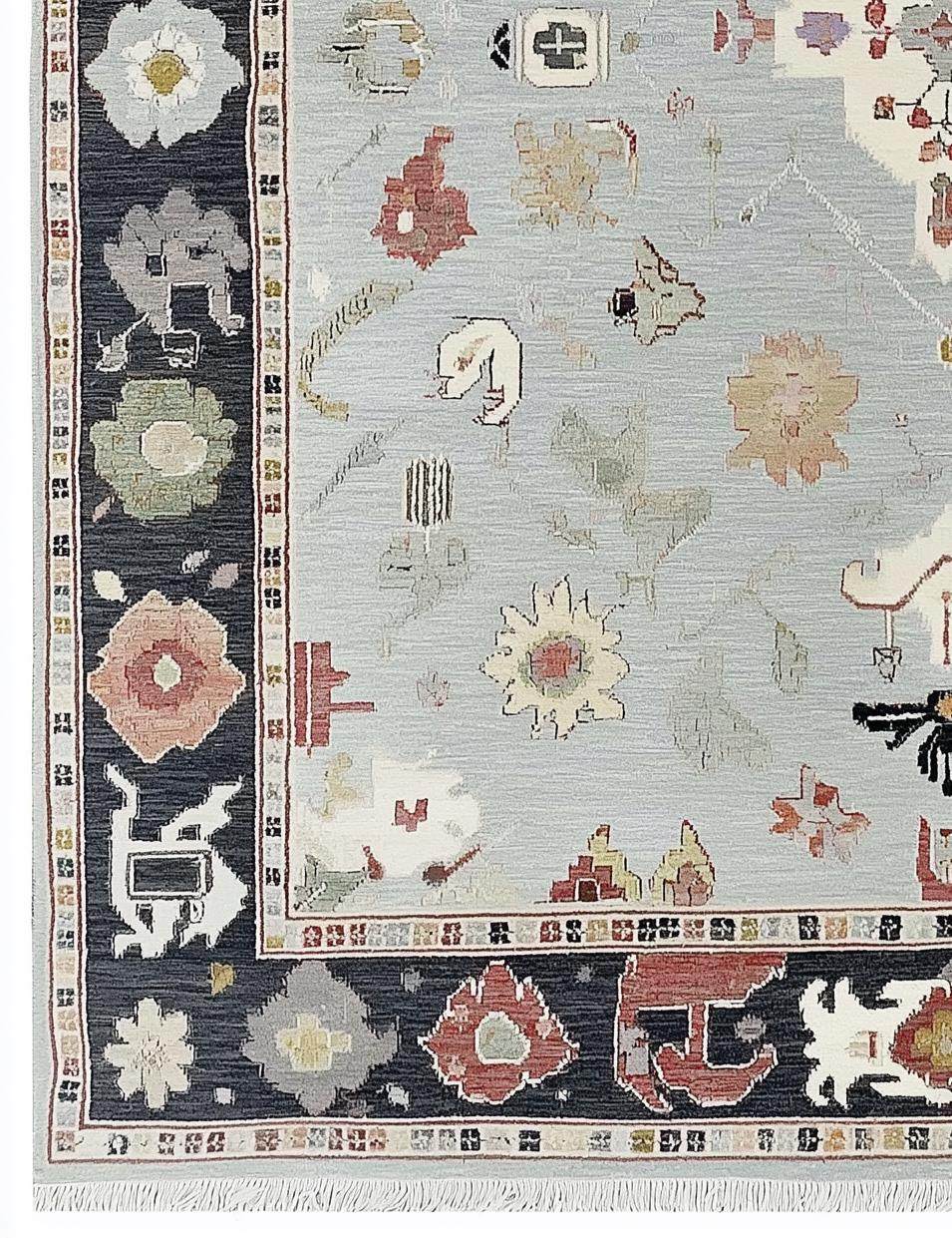 Light Blue Oushak Rug with navy border and floral medallion design, hand-tufted wool carpet
