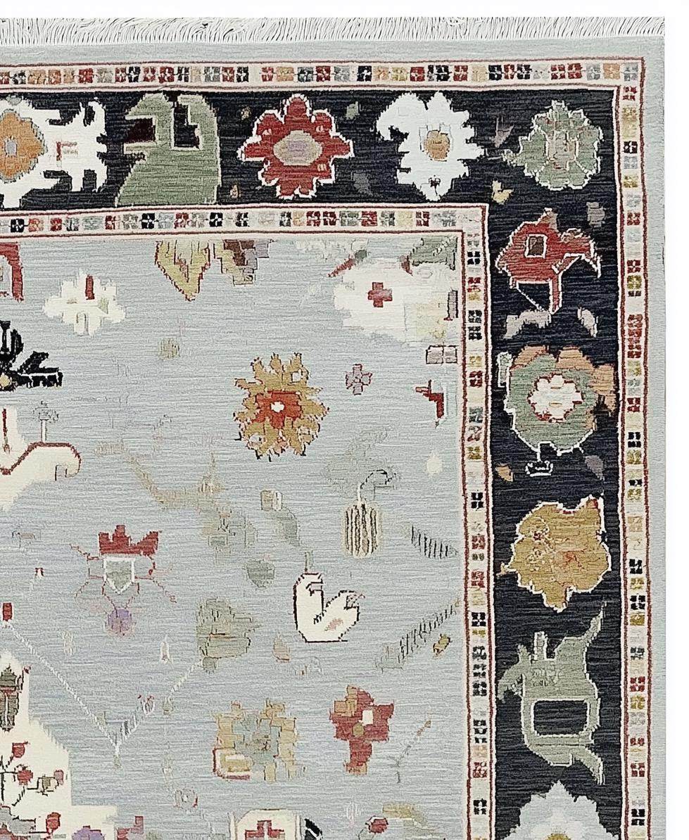 Light Blue Oushak Rug with hand-tufted wool, floral medallion, and navy border design