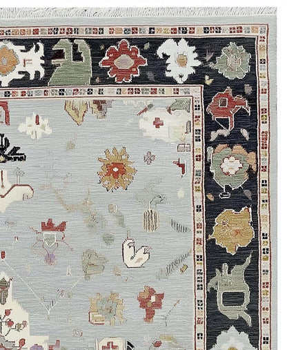 Light Blue Oushak Rug with hand-tufted wool, floral medallion, and navy border design