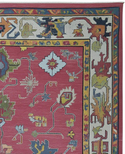Red abstract floral knotted area rug with colorful geometric motifs and detailed border in boho Turkish style