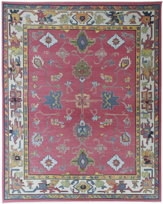 Full view of a rose pink Oushak style area rug with multi-color geometric and floral medallions; hand-tufted.