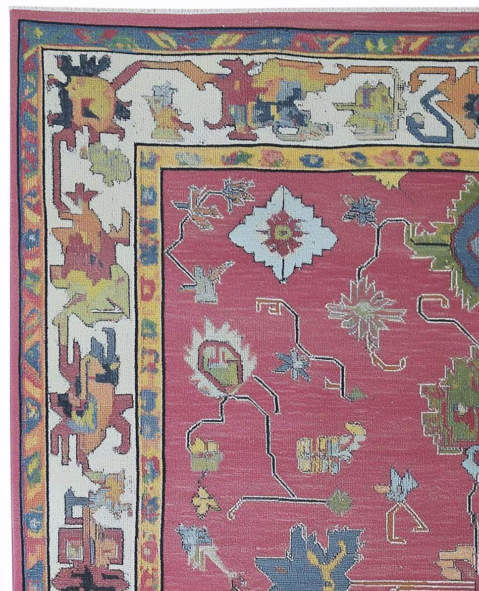 Red abstract floral knotted area rug with colorful geometric motifs and detailed border in boho Turkish style