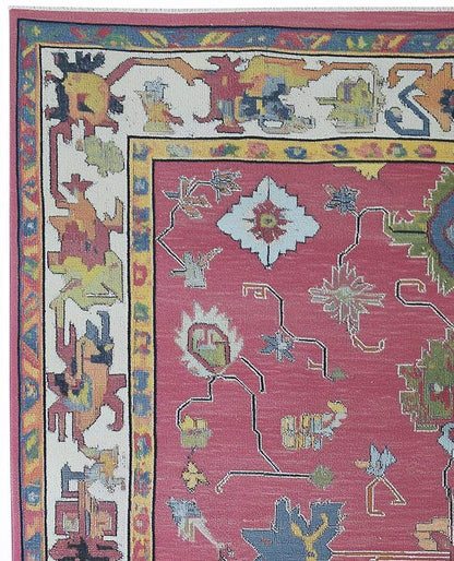 Red abstract floral knotted area rug with colorful geometric motifs and detailed border in boho Turkish style
