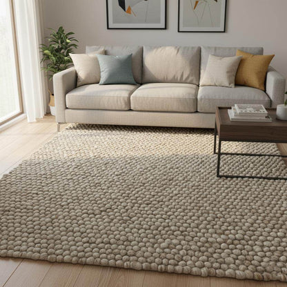 Handmade textured wool mat in natural beige with chunky pebble design for modern home décor