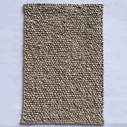 Handmade textured wool mat in natural beige pebble design for cozy modern home decor