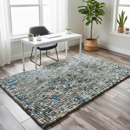 Handcrafted felt ball rug in teal, beige, and grey wool with pebble texture