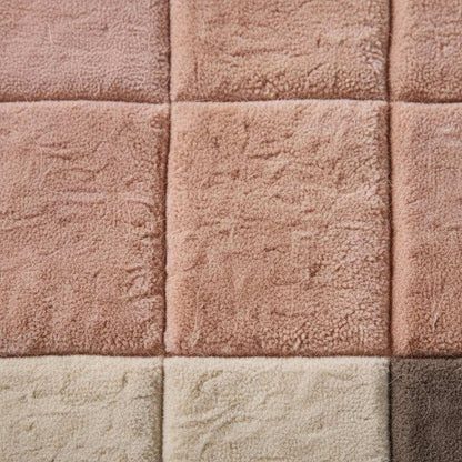 Modern geometric rug with plush pink neutral tones and textured grid pattern