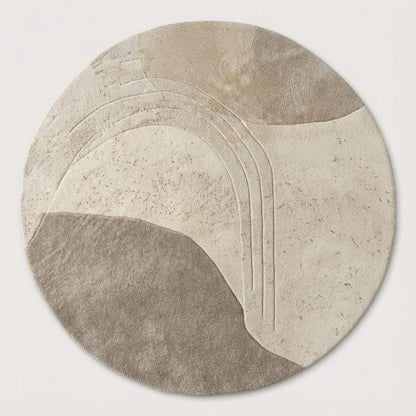 Hand-tufted circular wool rug featuring carved textured patterns on light wood flooring in a modern Scandinavian interior.
