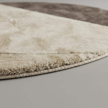 Modern round area rug with two tone cream and taupe colors and plush tufted texture