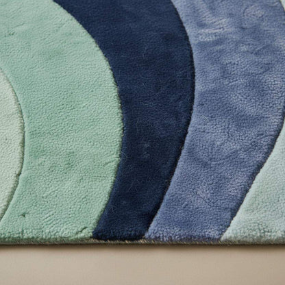 Modern abstract wave rug with sculpted pile and soft plush comfort in mint, navy, and blue tones