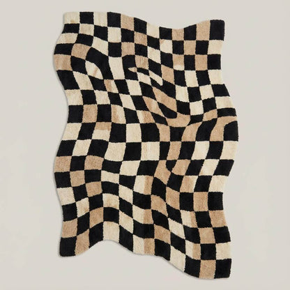 Soft tufted wavy check rug styled with mid-century furniture on hardwood floors for a trendy modern home aesthetic.