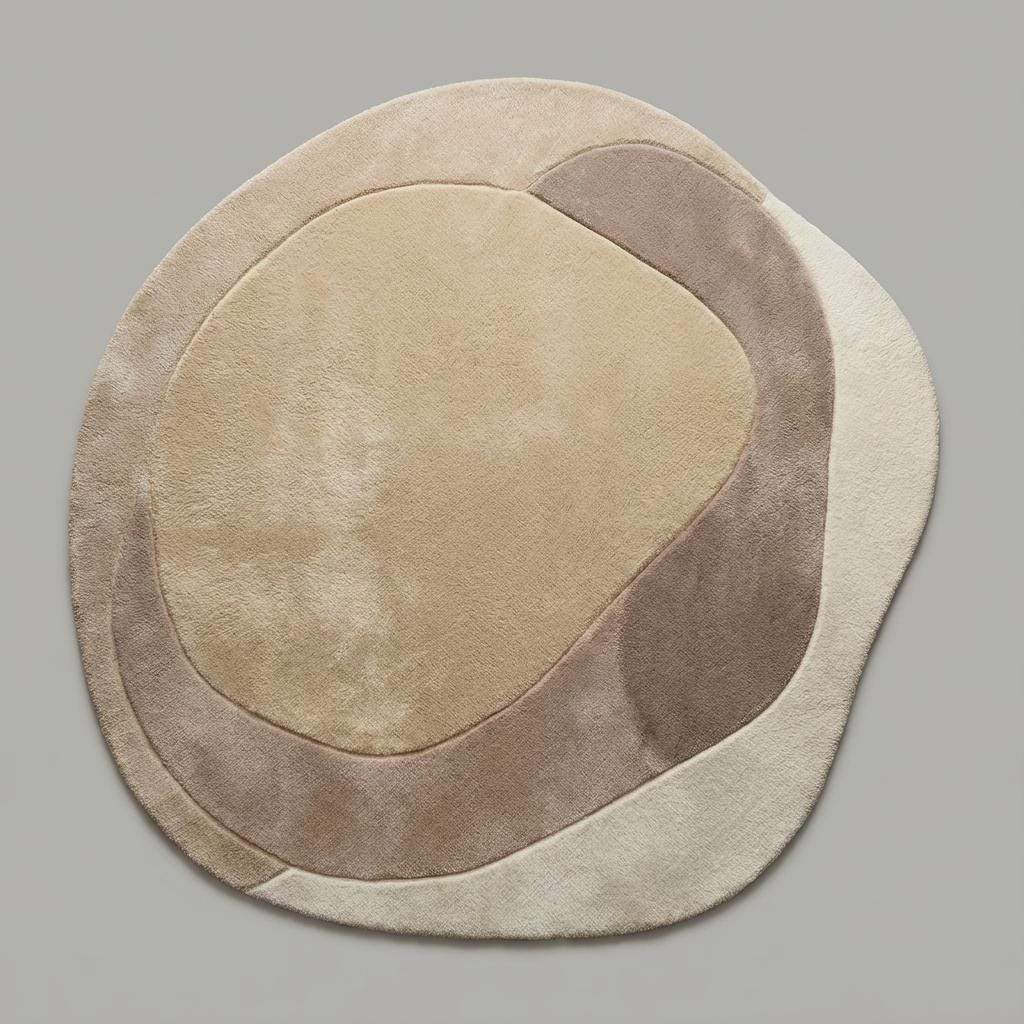 Neutral curved beige and cream rug with sculpted texture styled in a modern Scandinavian living space.