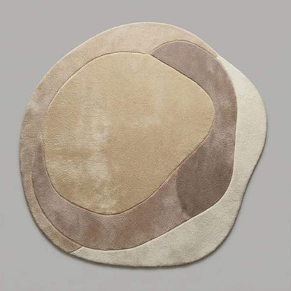 Neutral curved beige and cream rug with sculpted texture styled in a modern Scandinavian living space.