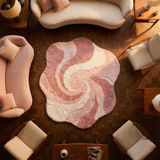 Pink abstract rug with irregular shape and wavy swirl pattern in plush shag material