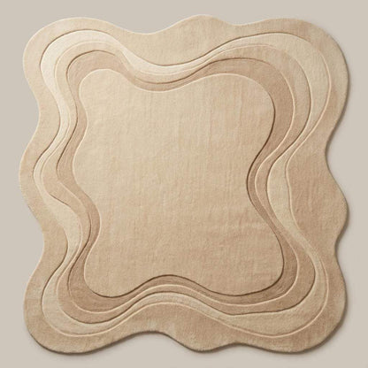 Modern abstract rug in warm beige tone featuring soft organic silhouette and plush textured surface