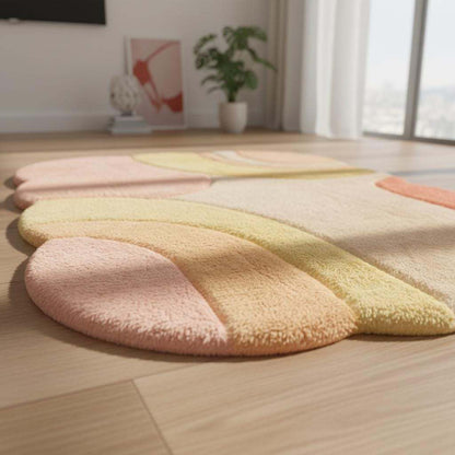 Modern abstract area rug in blush pink, cream, and soft yellow tones, adding artistic warmth to a stylish living room.